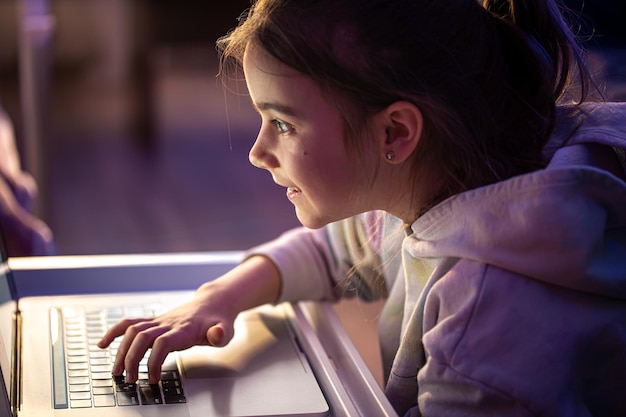 Una bambina usa un laptop a tarda notte