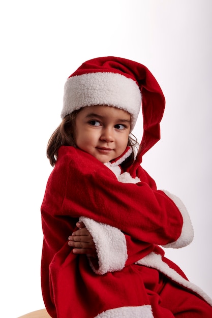 Una bambina vestita da Babbo Natale su sfondo bianco