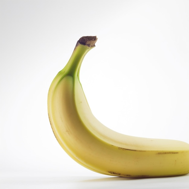 Una banana con una punta verde è appoggiata su una superficie bianca.