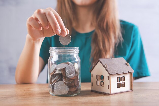 Una banca con le monete e una casa sul tavolo