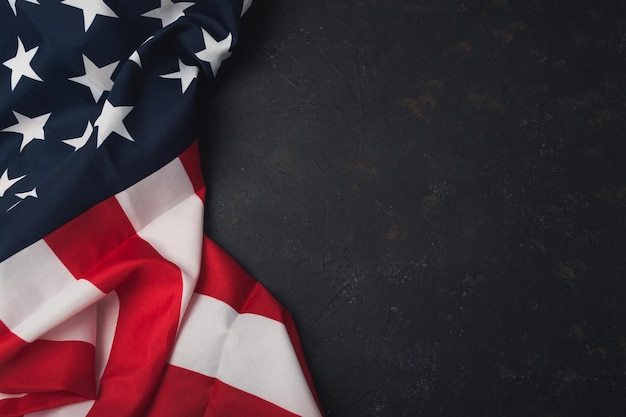 Una bandiera americana rossa e bianca è drappeggiata su uno sfondo nero