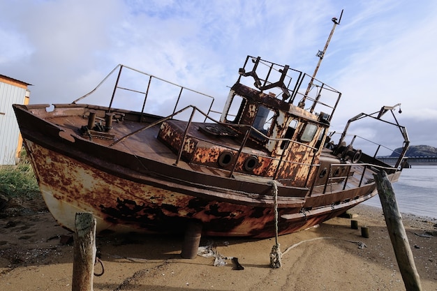 Una barca arrugginita sulla riva del Mar Bianco. La nave è arenata. Nord.