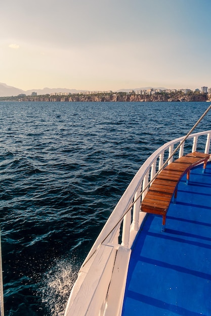 Una barca con un ponte blu e una vista della città di agia marina.