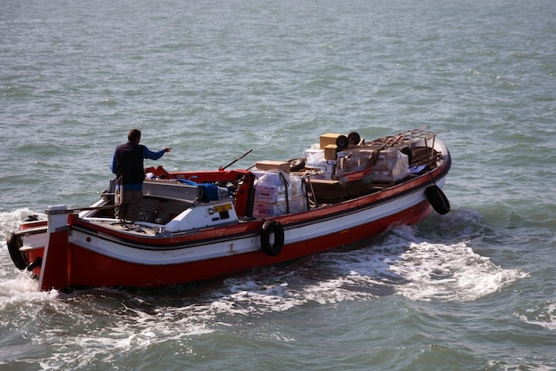 Una barca da trasporto motorizzata trasporta il carico sulle onde della schiuma del mare