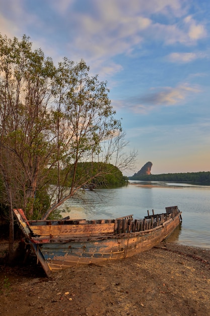 Una barca distrutta su una sponda del fiume Krabi.