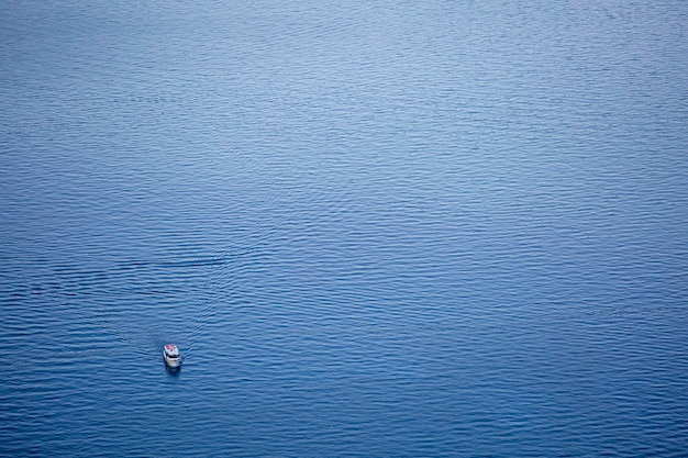 Una barca è nell'acqua blu profonda vista dall'alto