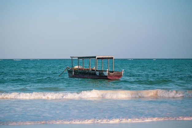 Una barca è nell'oceano e l'acqua è blu e bianca.