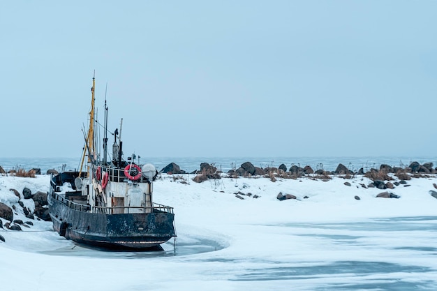 Una barca è nella neve e il ghiaccio è ghiacciato.