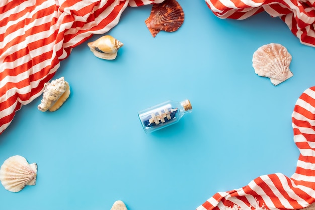 una barca in bottiglia e conchiglie su sfondo blu