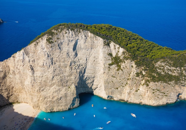 Una barca nella laguna vicino alla spiaggia di Navagio Isola di Zante Grecia Vista sulla baia del mare e barche da un drone Acqua di mare blu Vacanze e viaggi Paesaggio estivo dall'aria