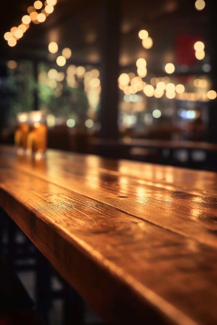 Una barra di legno con un bicchiere di birra sullo sfondo