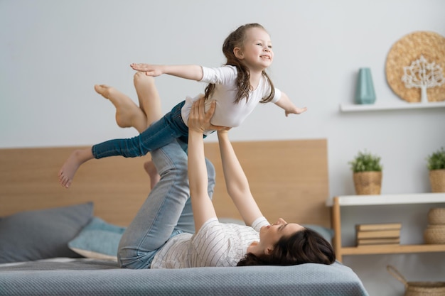 Una bella bambina e sua madre si godono la mattina di sole. Buon tempo a casa.