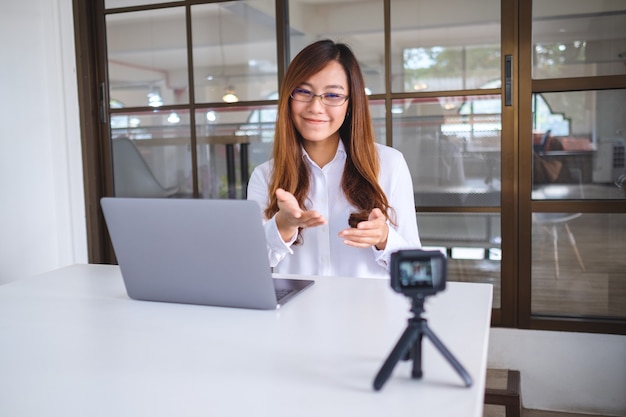 Una bella blogger o vlogger asiatica che registra un video