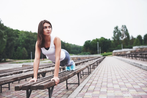 Una bella bruna atleta esegue esercizi all'aperto