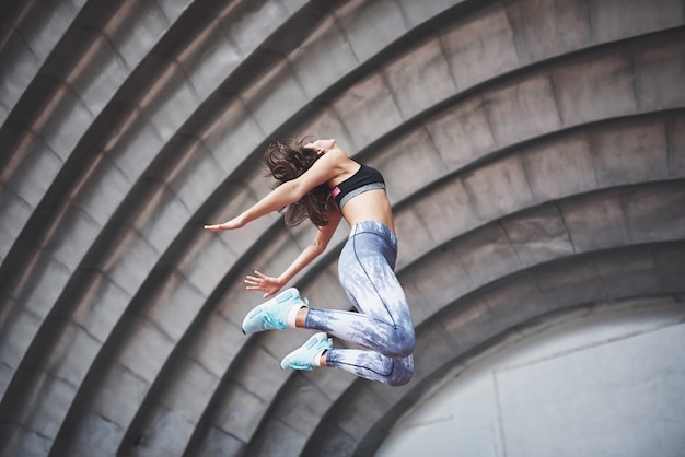 Una bella bruna atleta esegue esercizi all'aperto