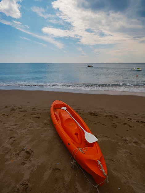 Una bella canoa rossa sulla spiaggia