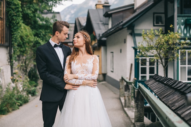 Una bella coppia di sposi cammina in una fata cittadina austriaca, Hallstatt.