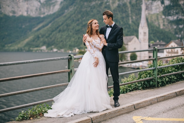 Una bella coppia di sposi cammina su una vecchia cattedrale di sfondo in una città austriaca fata