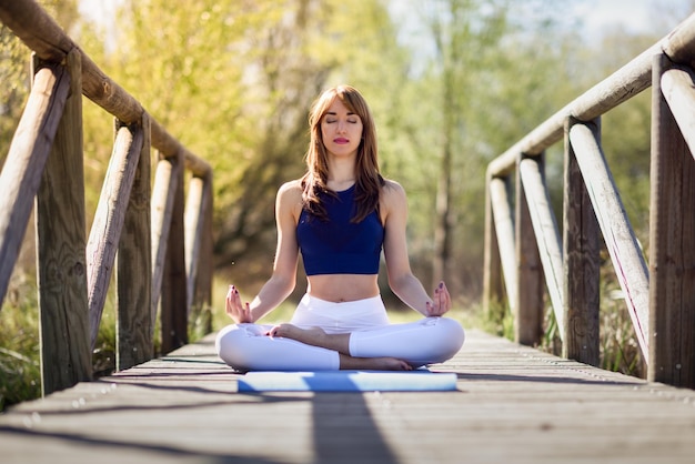 Una bella donna adulta che fa yoga sul lungomare.