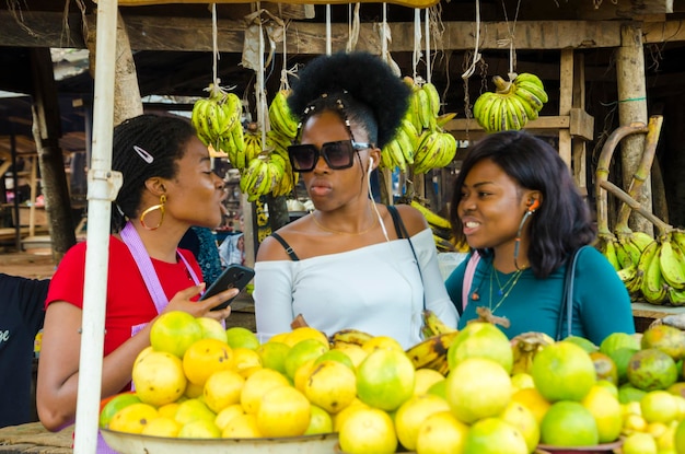 Una bella donna africana del mercato e i suoi clienti si emozionano mentre discutono