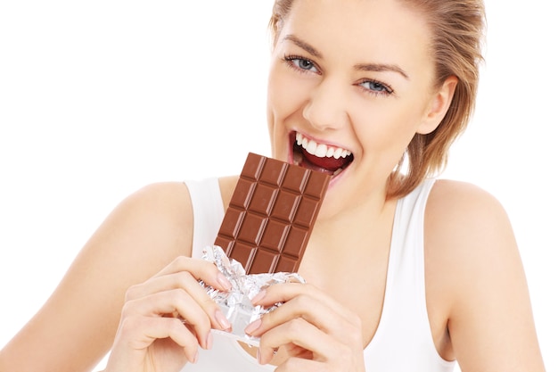 una bella donna che mangia cioccolato su sfondo bianco