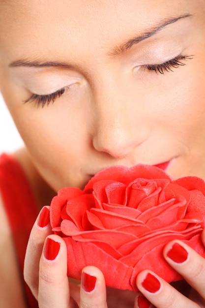una bella donna che odora una rosa rossa