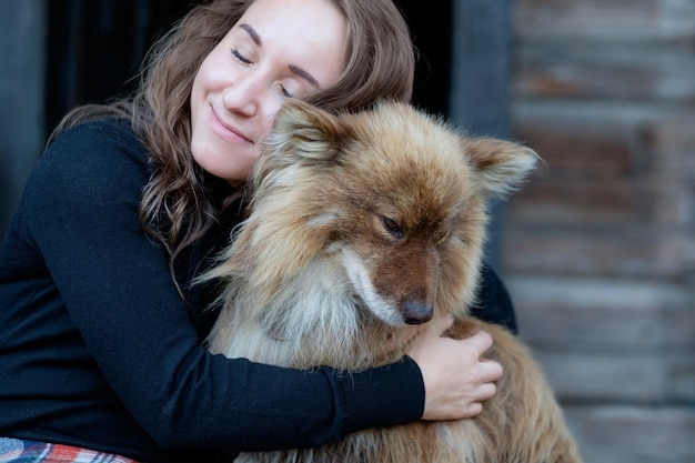 Una bella donna e il suo cane nenets pastore laika seduto