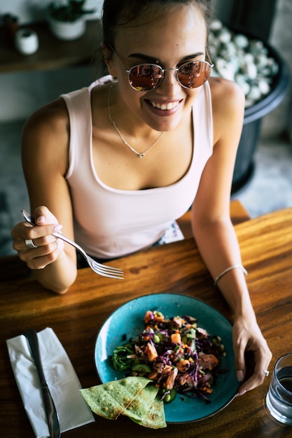 Una bella donna fa colazione in un elegante bar