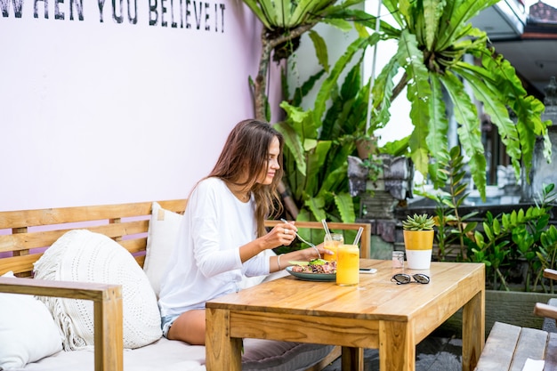 Una bella donna fa colazione in un elegante bar