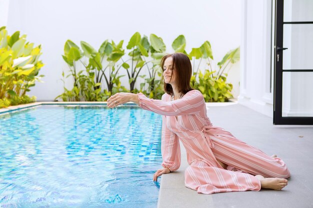 Una bella donna gioca nell'acqua vicino alla piscina