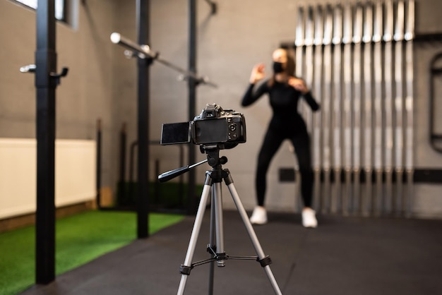 Una bella donna in forma riprende un allenamento sulla fotocamera