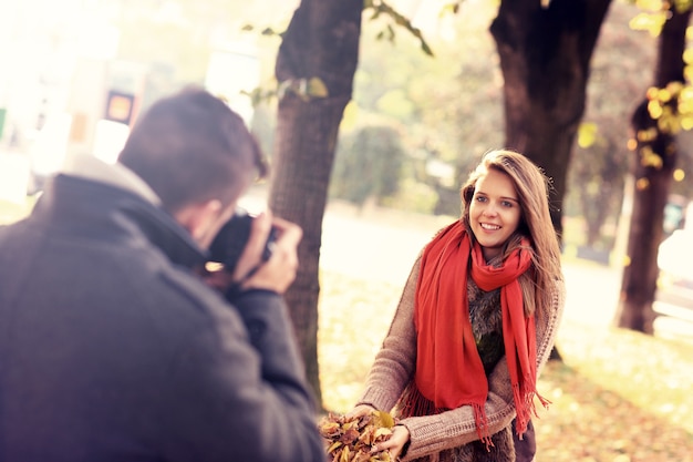 una bella donna in posa davanti alla telecamera nel parco in autunno