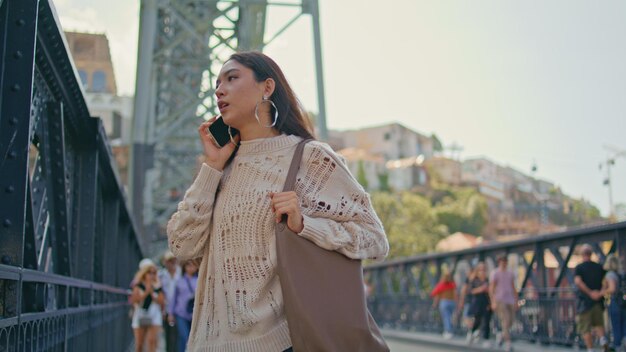 Una bella donna in primo piano che chiama un'amica che cammina per la strada della città estiva