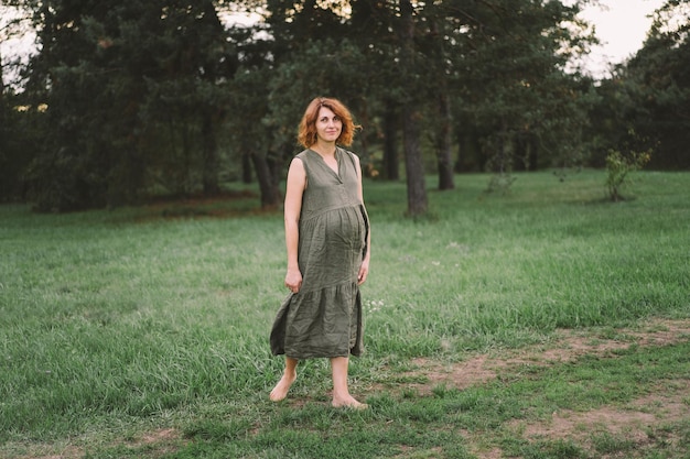 Una bella donna incinta all'aperto aspetta felicemente un bambino e un felice periodo di gravidanza Concetti di gravidanza e famiglia Maternità Pancia incinta Bambino in attesa