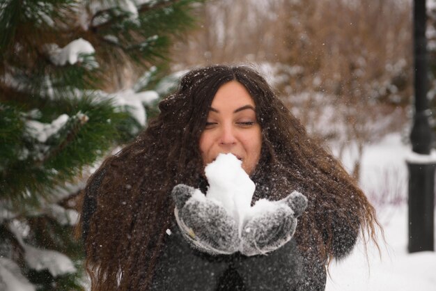 Una bella donna incinta sta giocando fuori nella neve