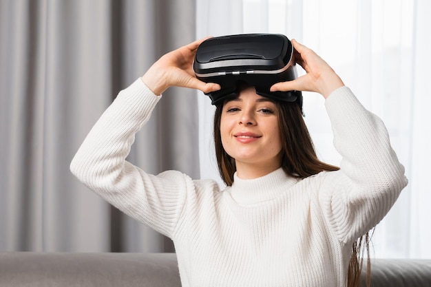 Una bella donna sorridente indossa occhiali vr per giocare a giochi di intrattenimento e tecnologia innovativa