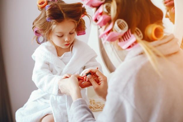 Una bella ed elegante mamma prepara la manicure per la sua piccola figlia