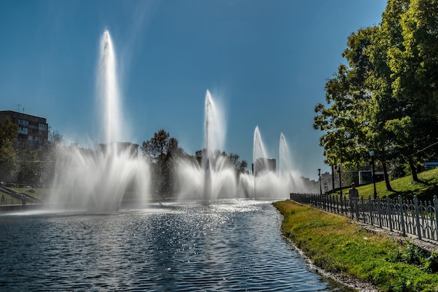 Una bella giornata nel parco pubblico Fontane blu cielo limpido sullo stagno alberi verdi ed erba