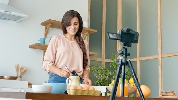 Una bella giovane donna che gira un blog sulla cucina video blog di cibo sano donna attraente è co...