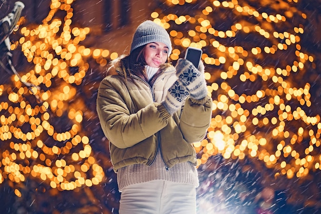 Una bella giovane donna che per mezzo del telefono all'aperto