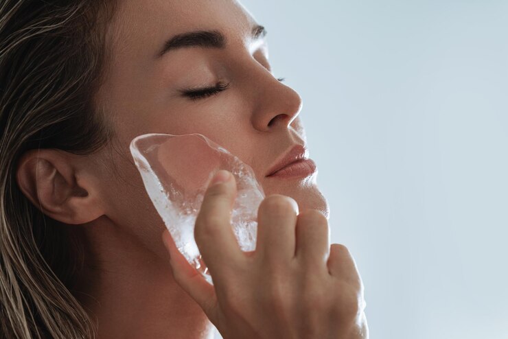 Foto una bella giovane donna che si applica la terapia del ghiaccio al viso