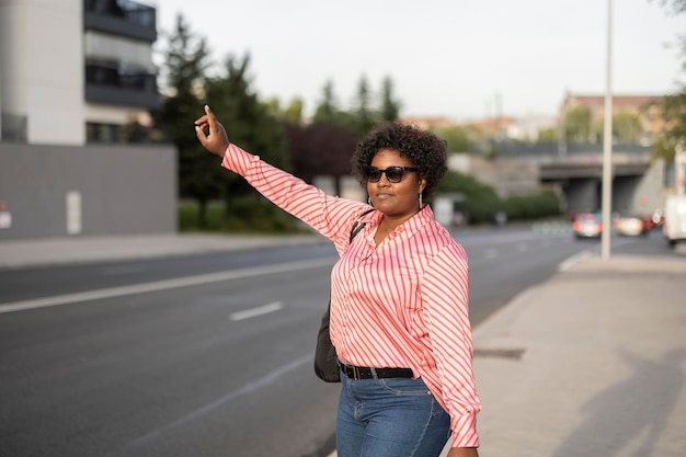 Una bella giovane donna d'affari saluta un taxi in città