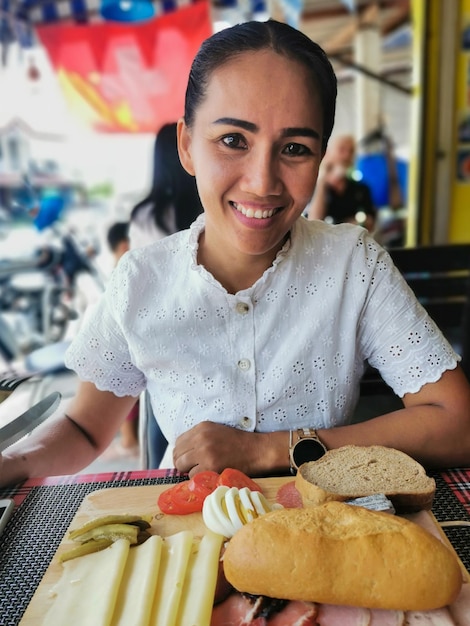 Una bella giovane donna davanti a un piatto da colazione rustico