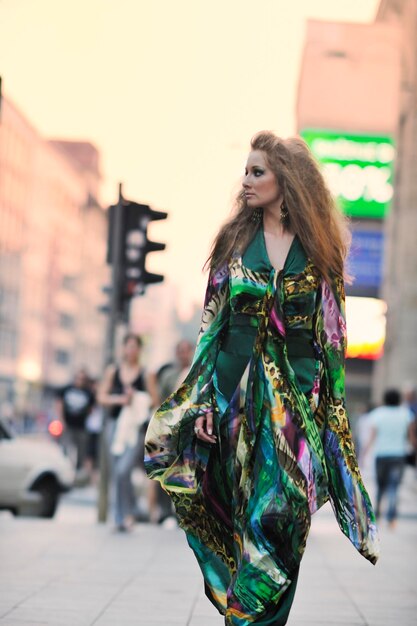 una bella giovane donna elegante nella moda e vestito in stile urbano in città sulla strada di notte da solo