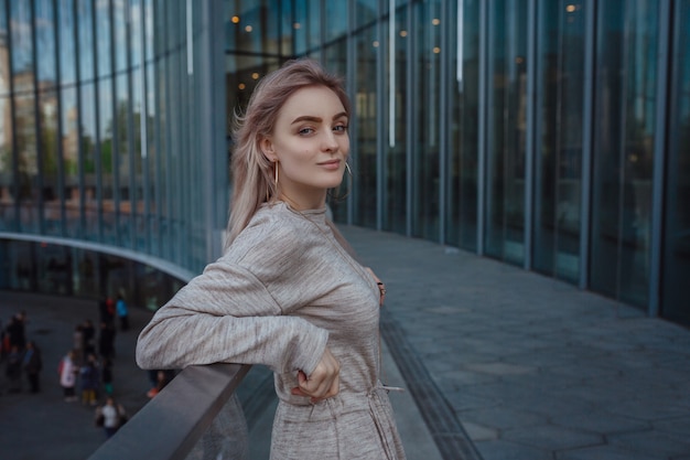 Una bella giovane donna in un abito in maglia beige cammina per le strade di Mosca, il famoso e popolare Parco Zaryadye proprio nel centro vicino alla Piazza Rossa