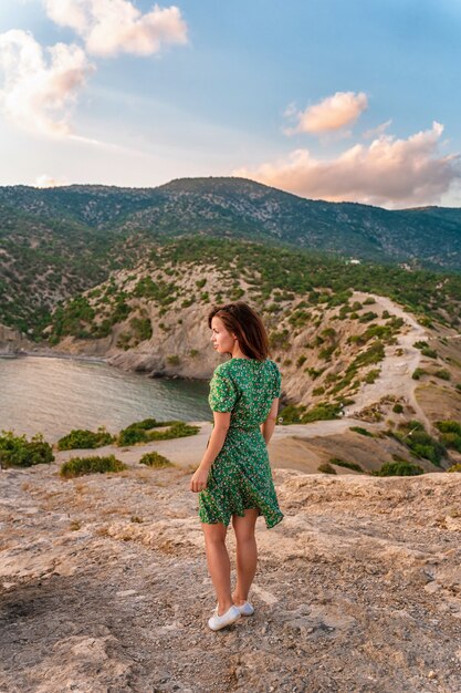 Una bella giovane donna in un vestito a Capo Kapchik nella romantica vista sul mare della Crimea