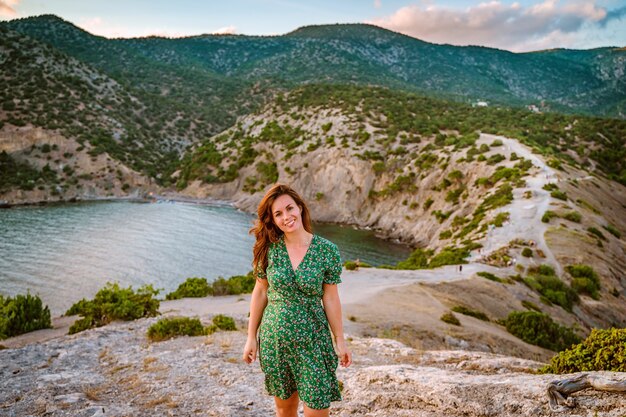 Una bella giovane donna in un vestito a Capo Kapchik nella romantica vista sul mare della Crimea