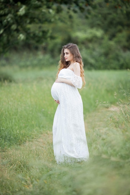 Una bella giovane donna incinta in posa