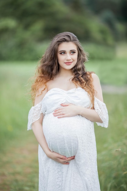 Una bella giovane donna incinta in posa