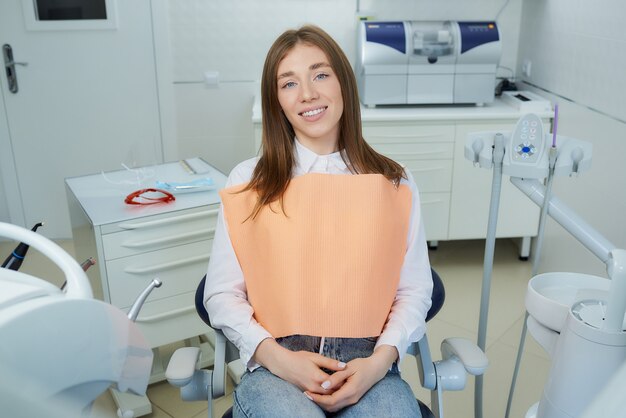 Una bella giovane donna rilassata sulla poltrona del dentista